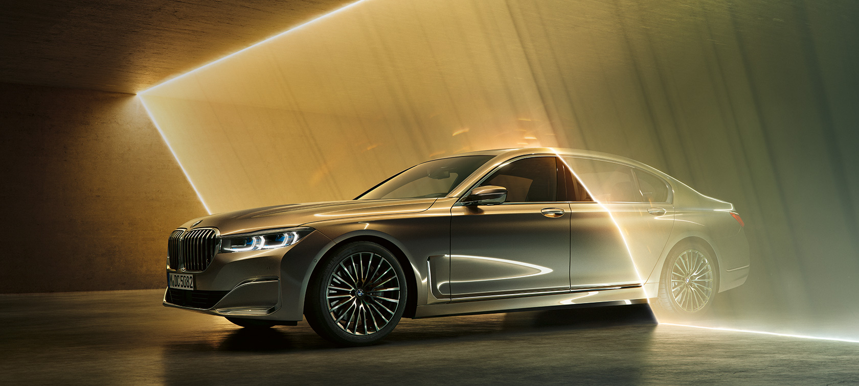 BMW 7 Series Sedan: grey BMW in three-quarter front view surrounded by beams of light