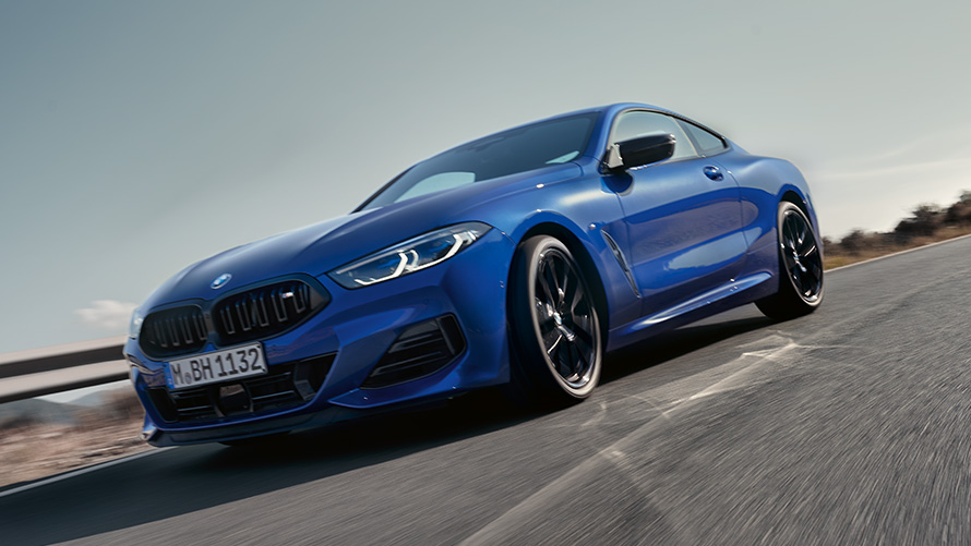 BMW M850i xDrive Coupé G15 LCI Facelift 2022 M Portimao Blue metallic three-quarter front view BMW M850i xDrive Coupé G15 LCI Facelift 2022 M Portimao Blue metallic three-quarter front view driving