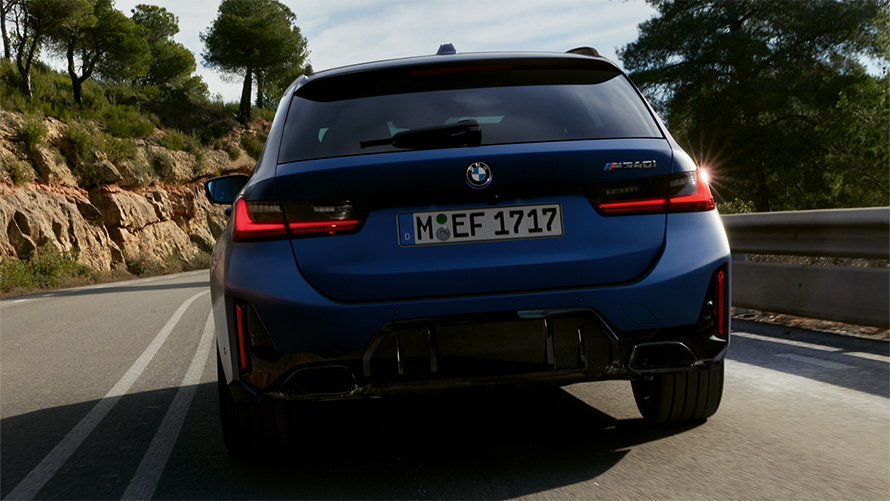 BMW M340i xDrive Touring G21 Frozen Tanzanite Blue rear view driving on the street