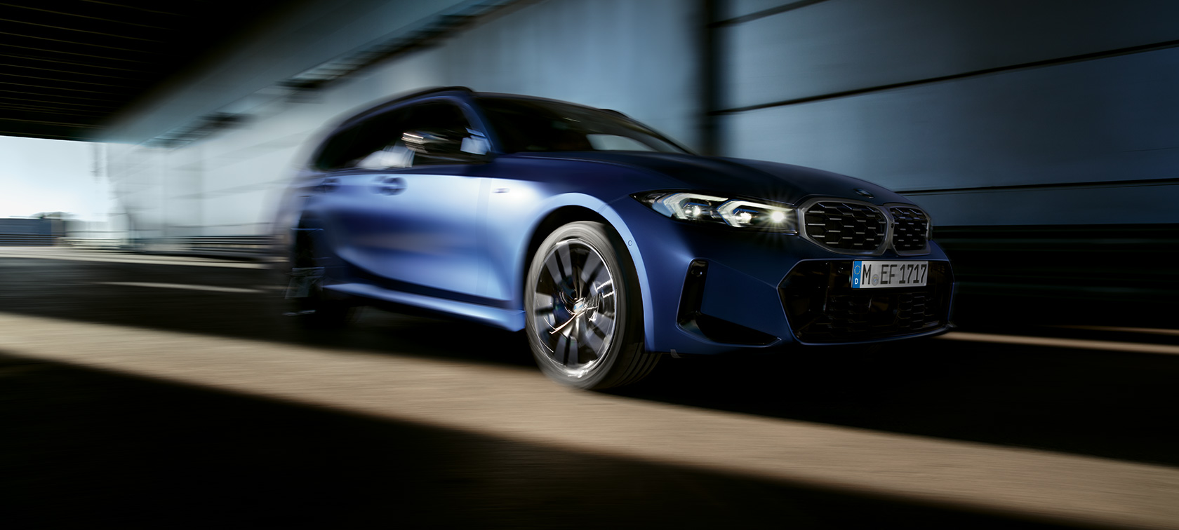 BMW M340i xDrive Touring G21 three-qaurter side view driving BMW M340i xDrive Touring G21 Frozen Tanzanite Blue three-qaurter side view driving