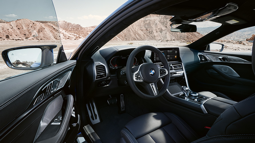 BMW M850i xDrive Coupé G15 LCI Facelift 2022 Driver-oriented cockpit with M leather steering wheel with open front door