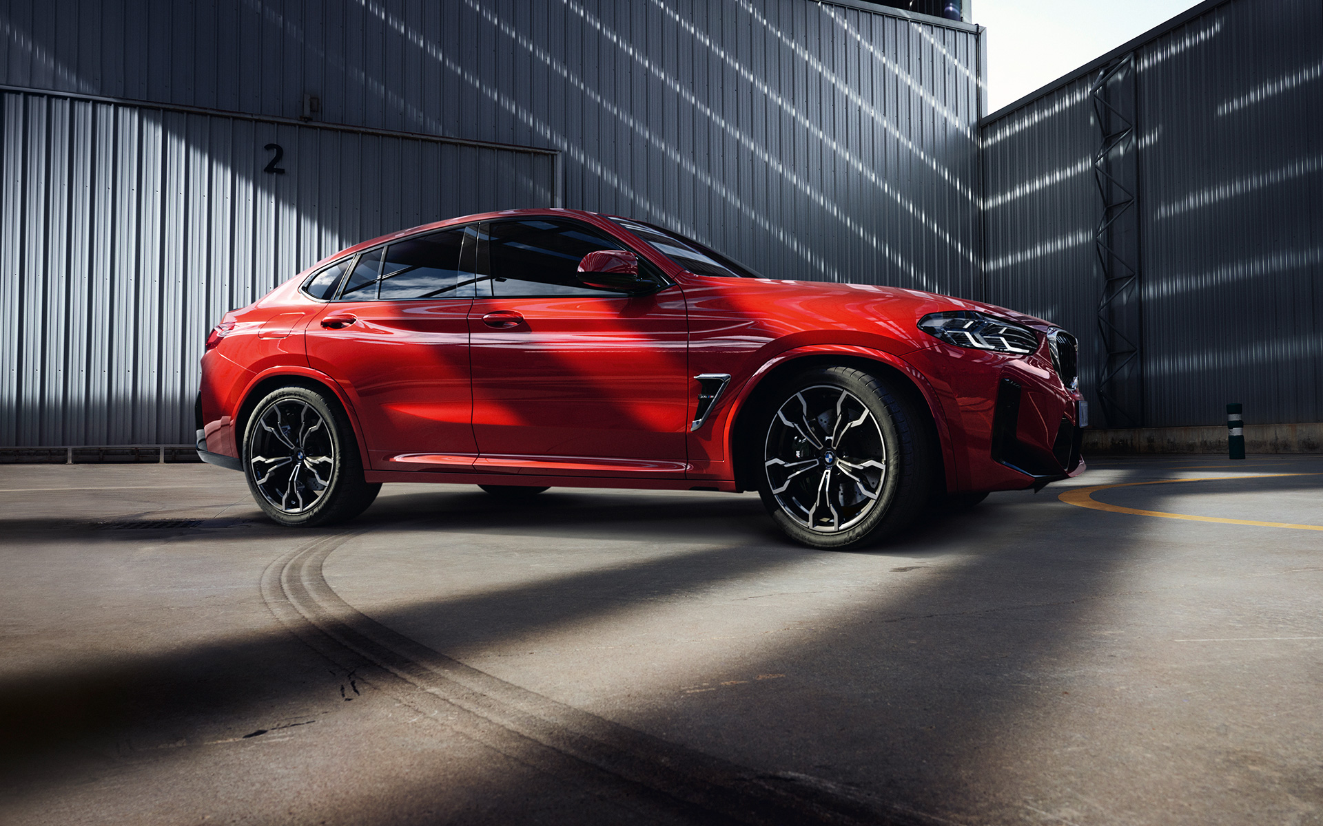 BMW X4 M F98 LCI Facelift 2021 Toronto Red metallic side view in front of factory building