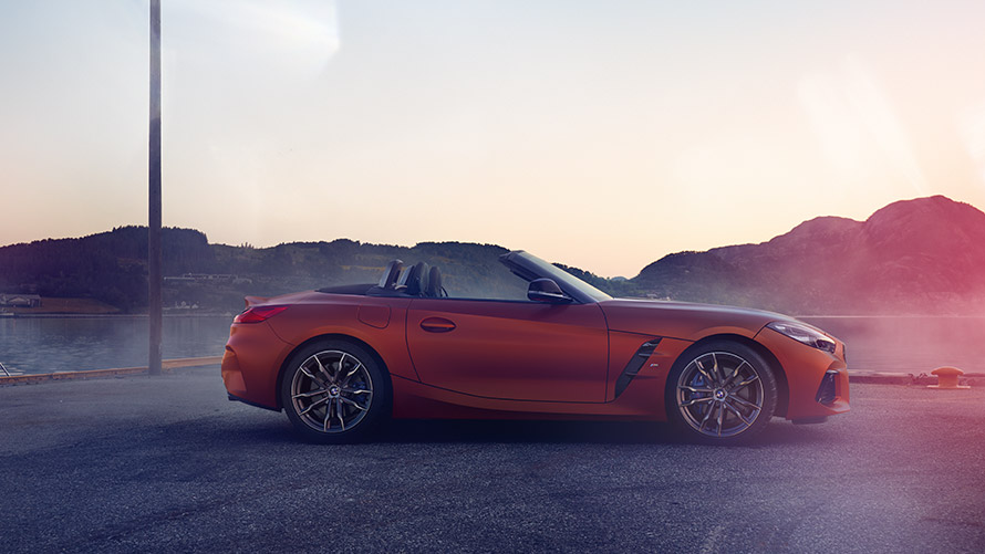 n Side view orange BMW Z4 First Edition Side view orange BMW Z4 First Edition in front of mountain view