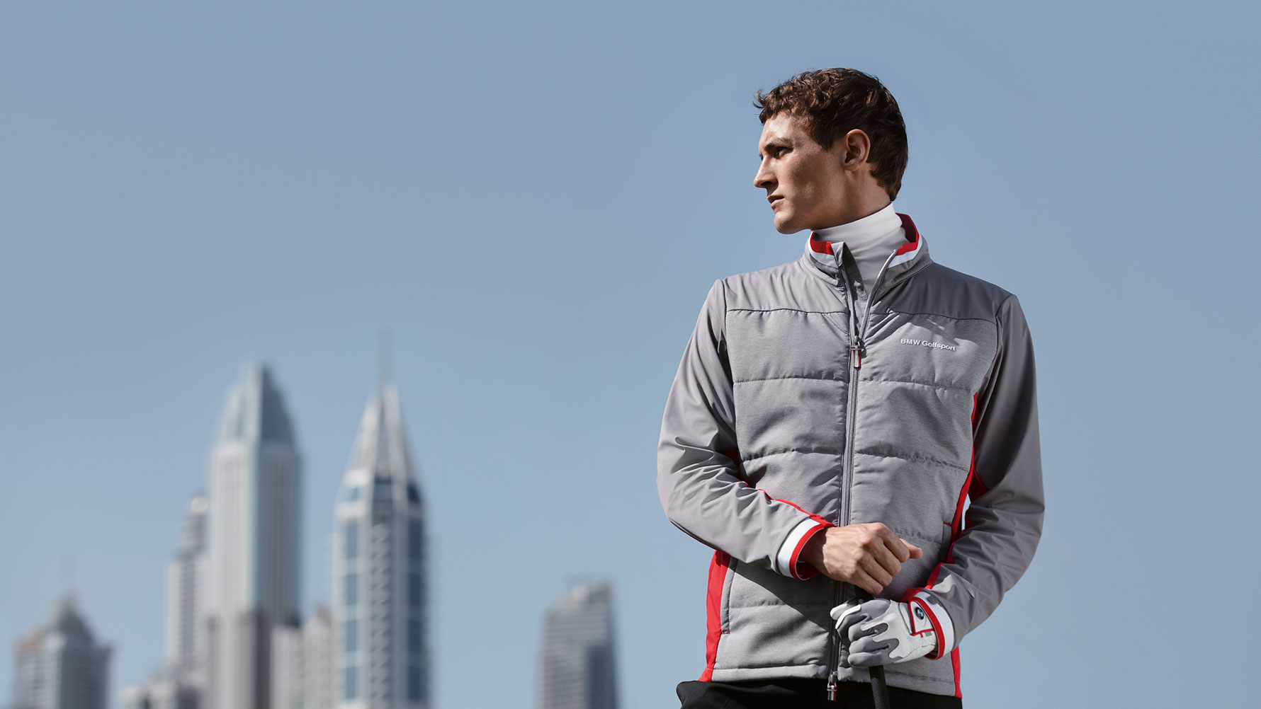 A male model presents products from the BMW Golfsport Collection against a backdrop of a big city skyline. A male model presents products from the BMW Golfsport Collection against a backdrop of a big city skyline.