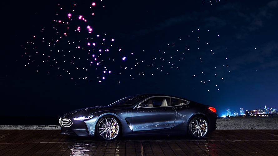 BMW Concept 8 Series The BMW 8 Series Concept stands under 300 illuminated drones sky at night