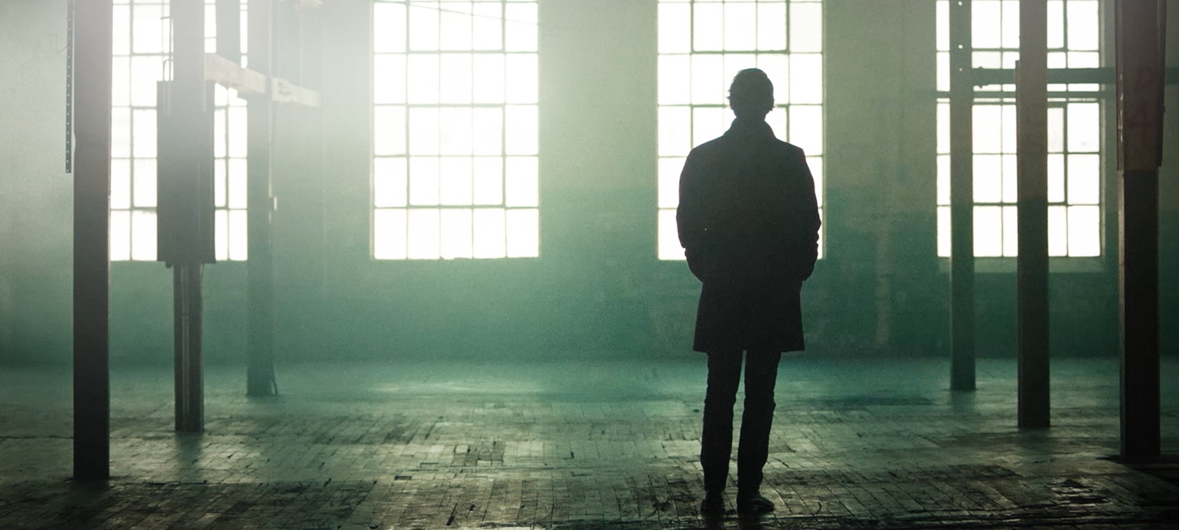 Bold Voices Bold Voices: Man stands in empty factory hall with large windows