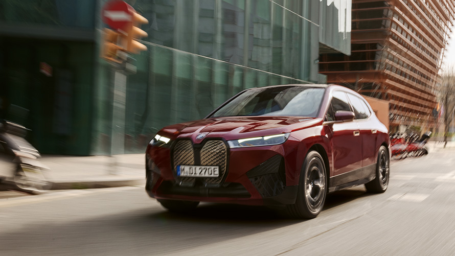 BMW i7 xDrive60 BMW Individual Dravite Grey metallic three-quarter front view driving on the street
