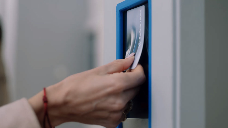 Person placing BMW Charging Card at public charging station Person placing BMW Charging Card at public charging station
