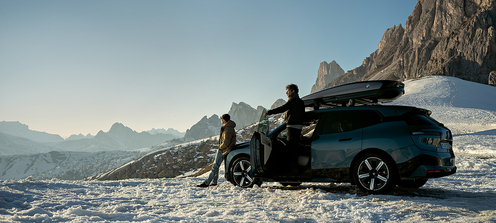Men with BMW iX in snowy landscape 